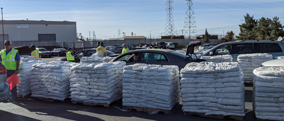 bags of compost on pallets and cars lined up to pick up 2 bag