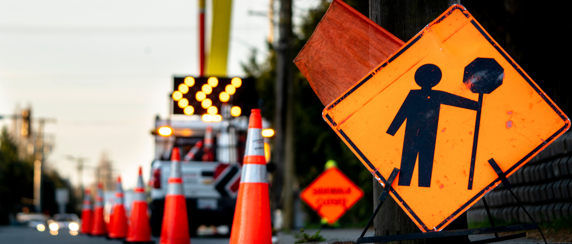 orange traffic cones and roadwork signs on roadway