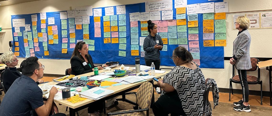 community members and stakeholders at a table providing feedback to facilitator as part of the FRC Strategic Plan meeting