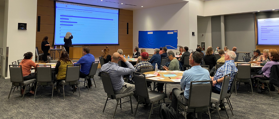community members attending a meeting and sitting at round table to discuss Fremont's Homeless Response Plan