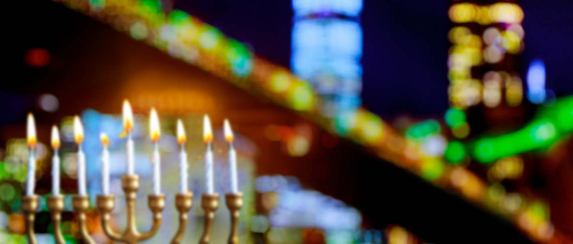 holiday lights on home and menorah with candles lit