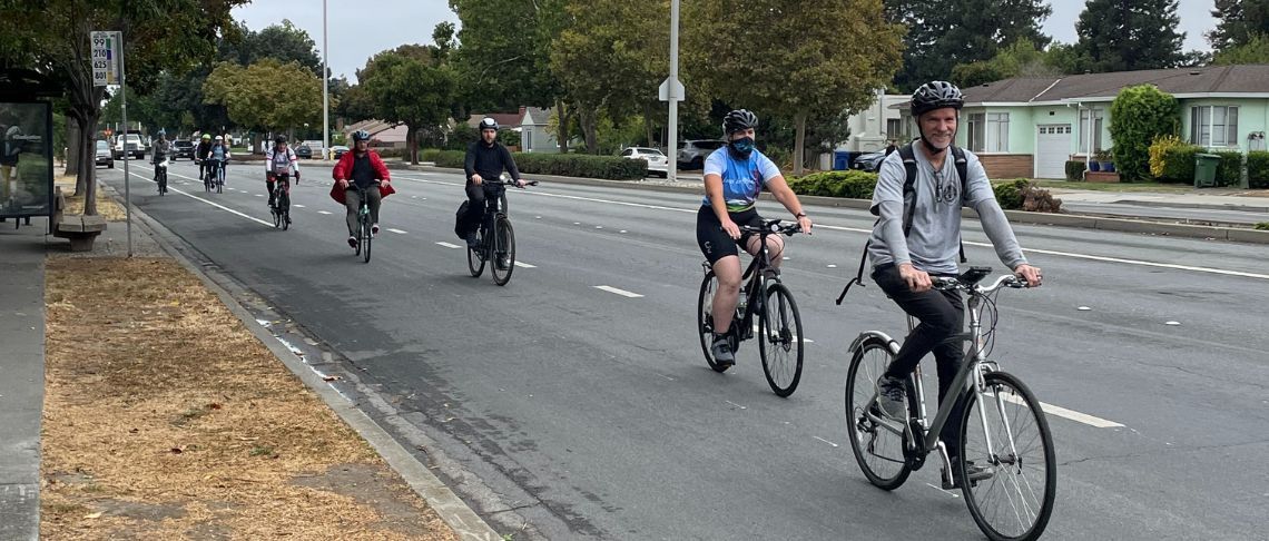 cyclists with helmets riding on Fremont roadway in bike line