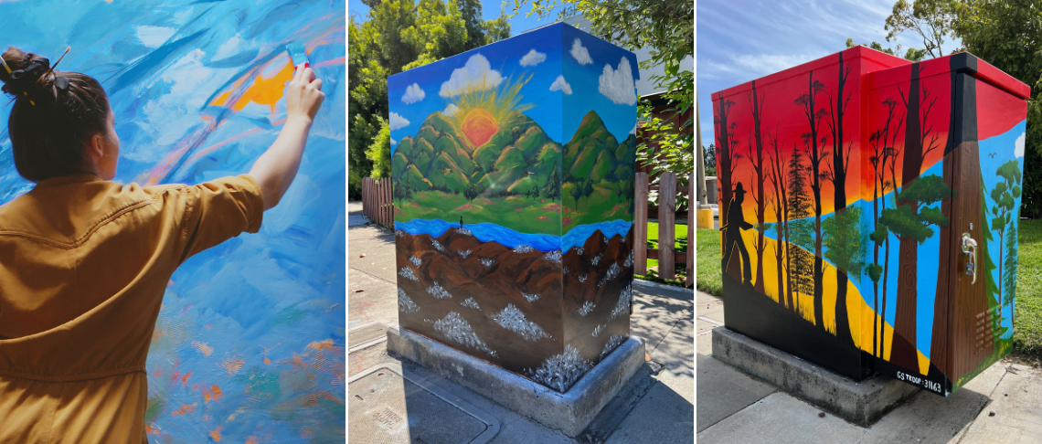 artist painting a traffic signal control box next to fully painted ones in bright colors and designs.