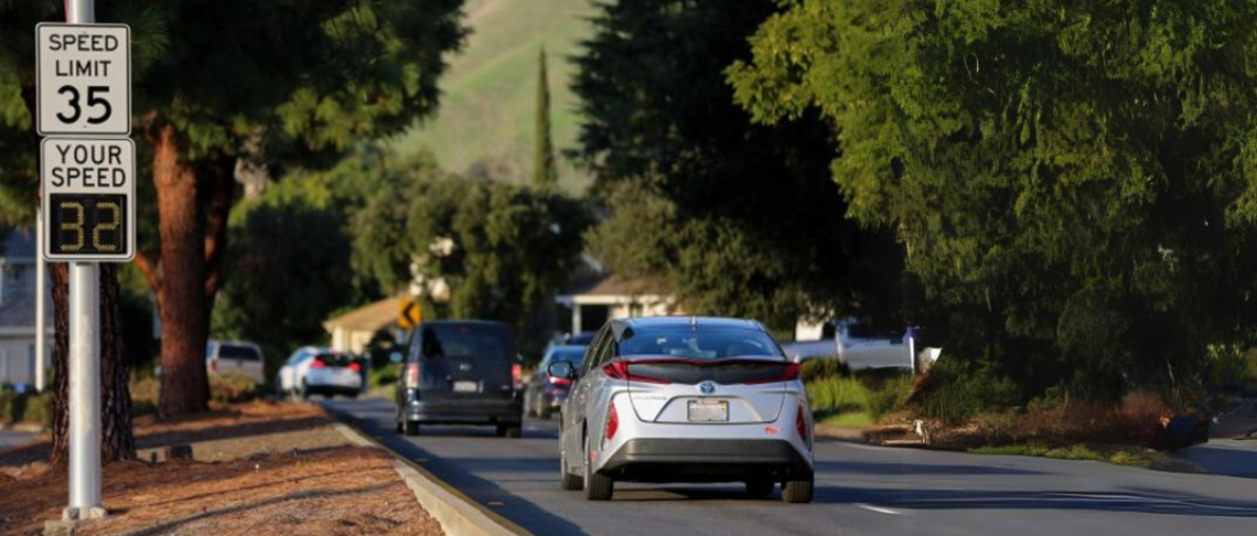 cars driving on street with speed limit signs
