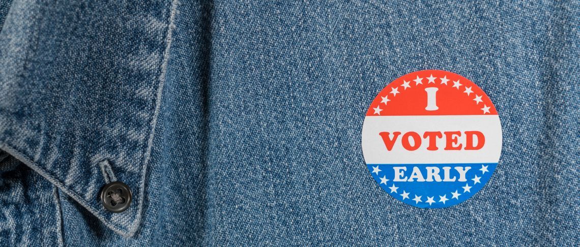 'I Voted Early" round sticker on denim shirt