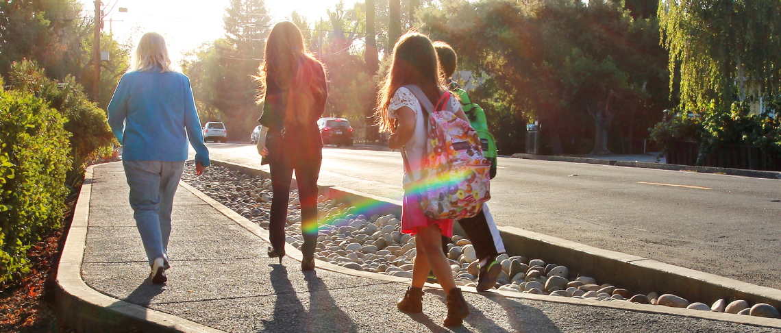 family walking on sidewalk togther