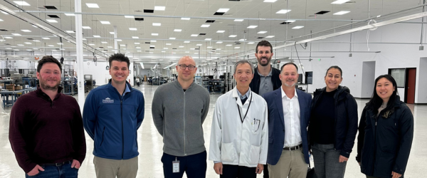 Group photo standing in Alpha EMS production facility