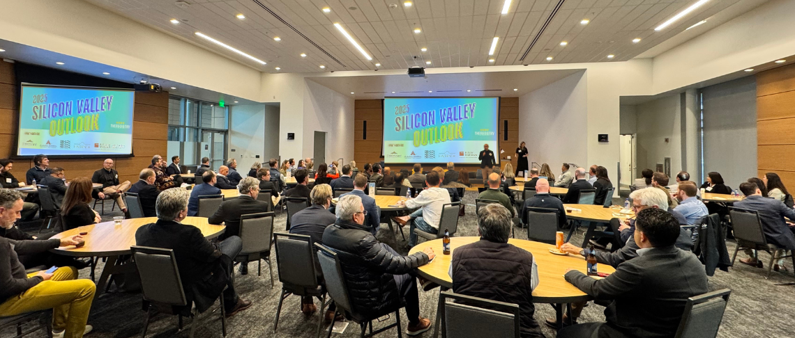 Full crowd listening to speaker onstage at Downtown Event Center