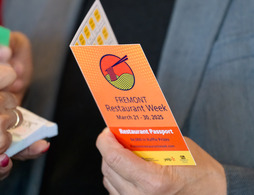 Man holding a passport for Restaurant Week 2025