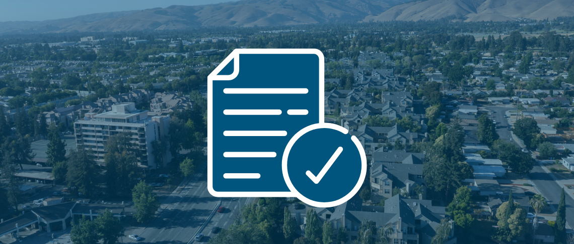 Aerial of Fremont in background. A document icon with a check mark in foreground.