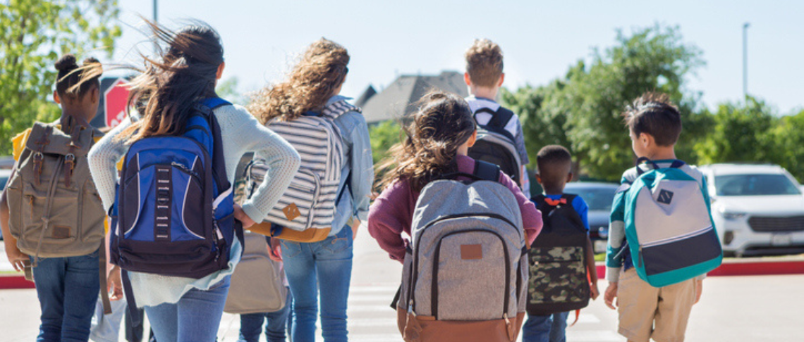 Back to School Tips. Image of kids with backpacks on.