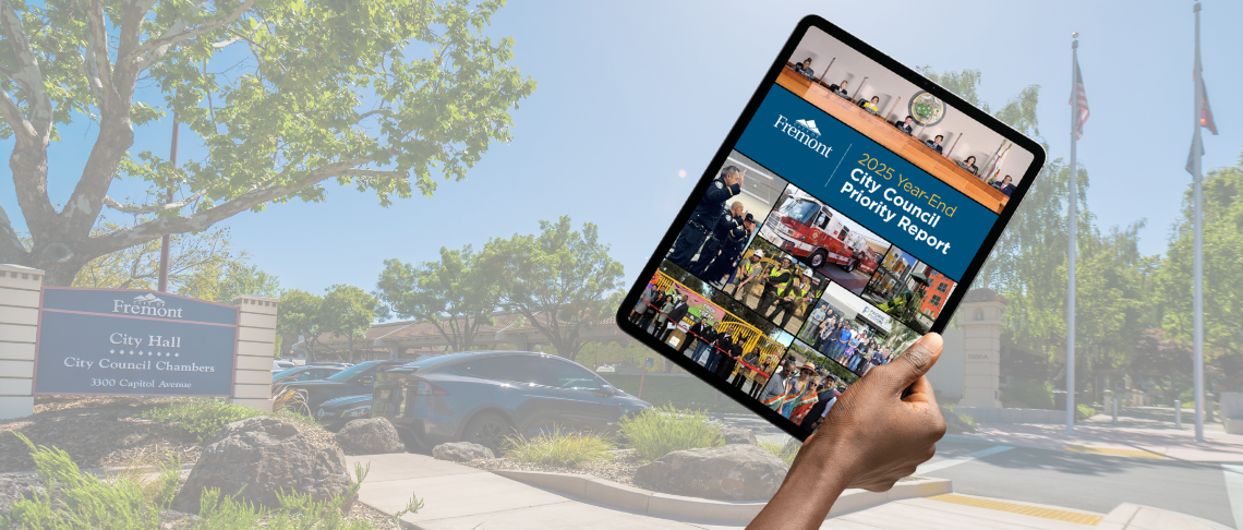 Hand holding a tablet with text: 2025 Year End Council Priority Report