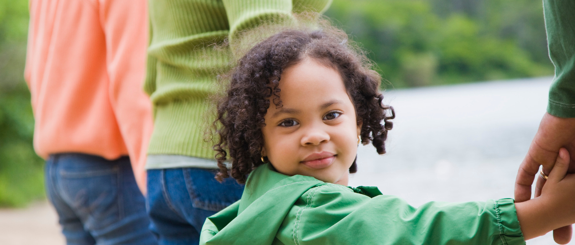 Young child holding parents' hands
