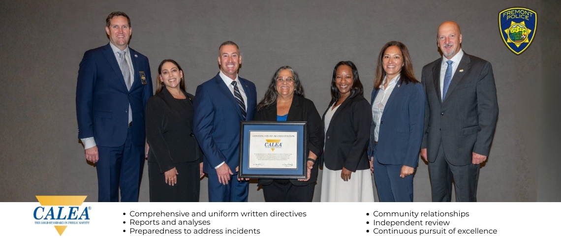Officials from City of Fremont and Fremont Police Department standing with CALEA representatives and holding a framed accreditation certificate