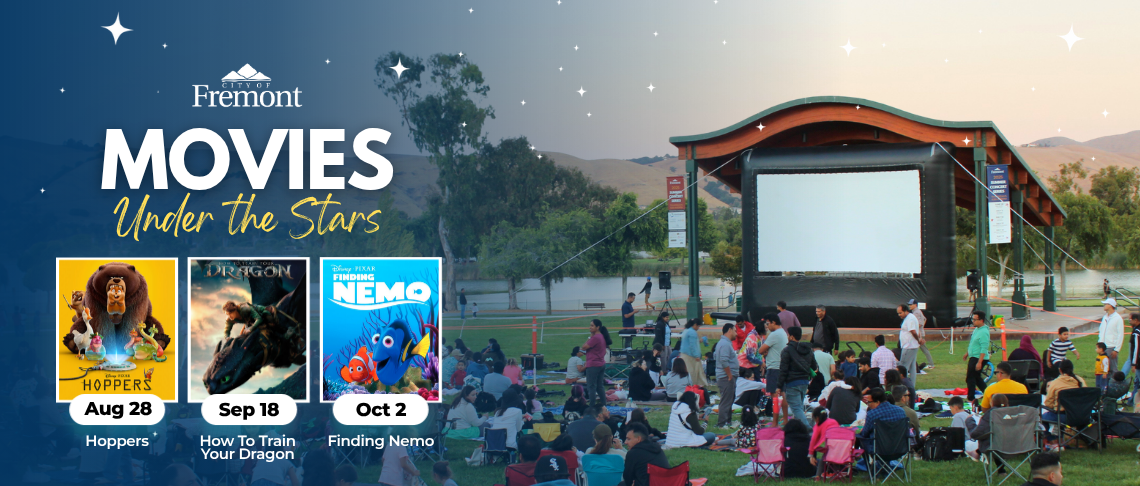Outdoor movie event at Fremont with families watching films under a twilight sky and a large screen on a stage.