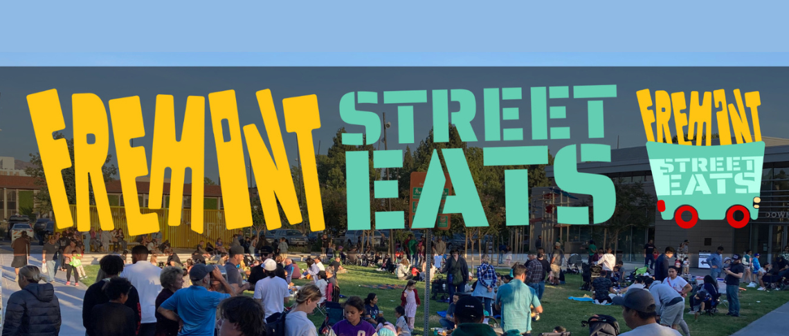Crowd enjoying outdoor dining and socializing at Fremont Street Eats food event in a park setting.