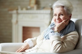 Elderly woman sitting on an armchair smiling