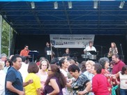 groups of people dancing in front of a stage with a band playing music