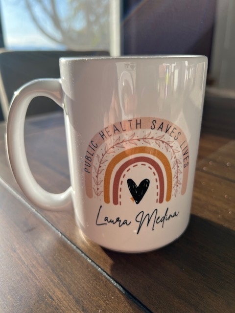 mug with a heart at the center of a rainbow saying, "public health saves lives." 