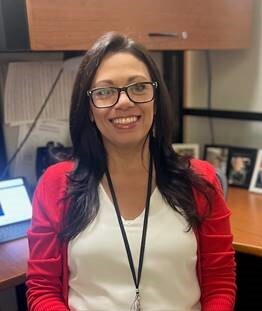 Jessica Silva smiling for the camera in front of her desk.