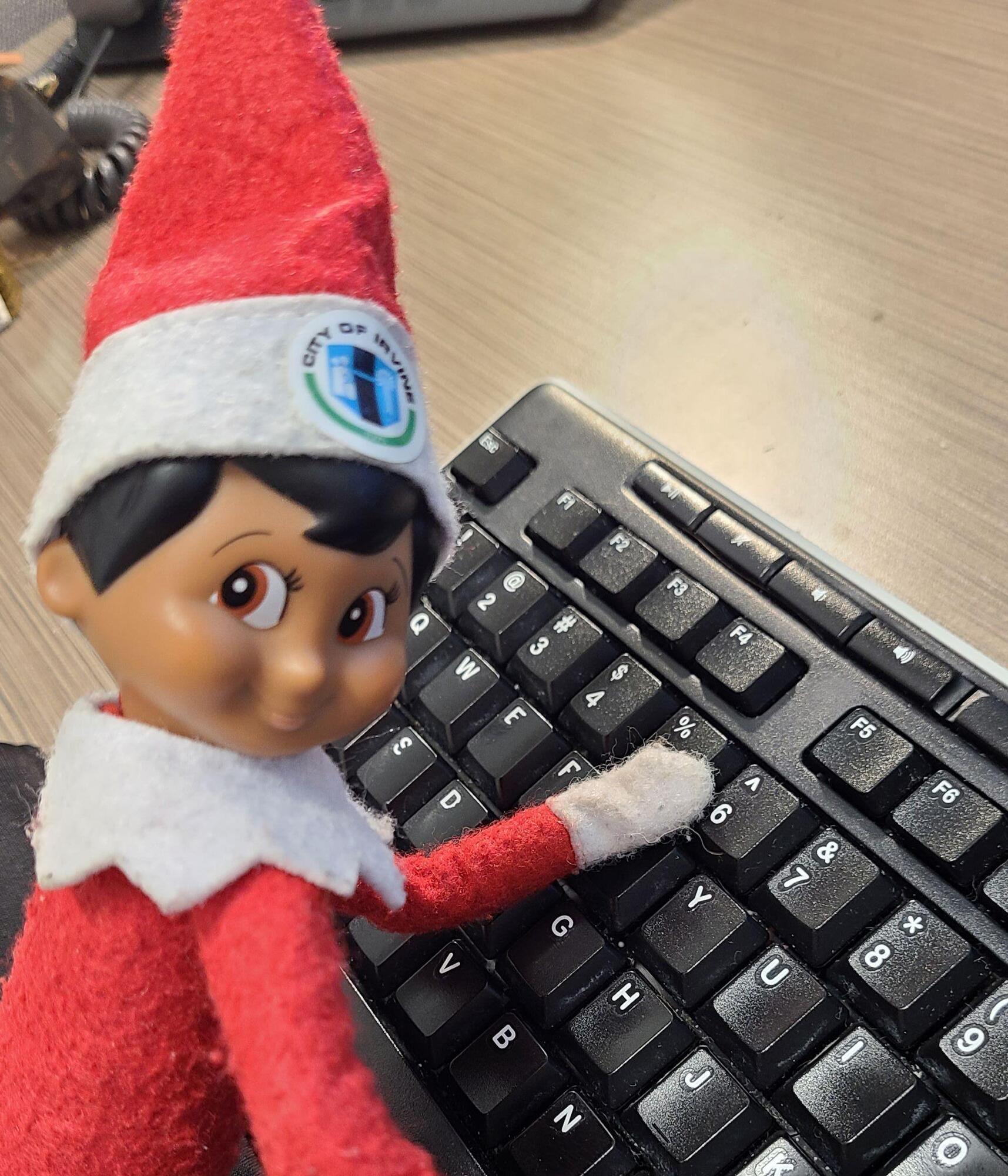 Elf on a Shelf typing on a computer