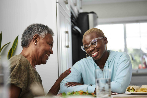 Older African-American woman talking to a young adult African-American woman. 
