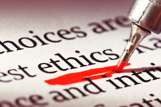 a red pen highlights beneath the word ethics in a closeup of a page in a book