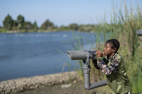 Child looking through binoculars at Earvin "Magic" Johnson Recreation Area