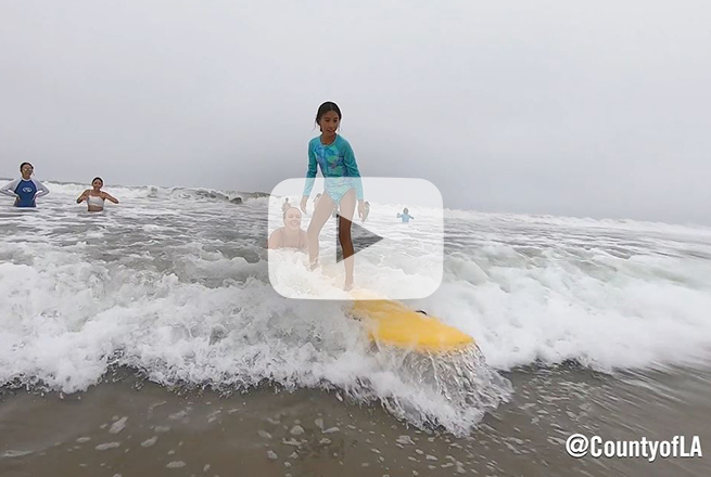 Girl on top of surf board at the beach