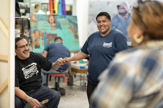 Two smiling men fist bumping at Homeboy Arts Academy in East Los Angeles