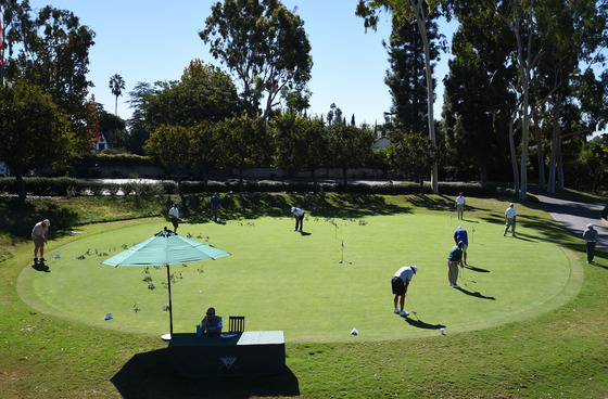 Group of golfers at a putting green practicing