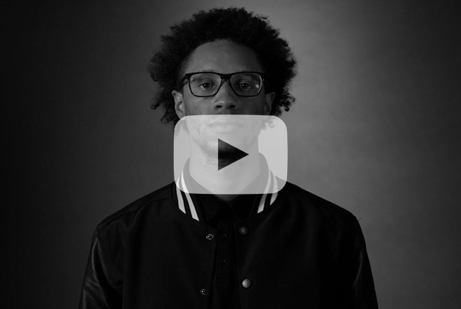 Close up photo shot of male with afro and glasses and leather jacket