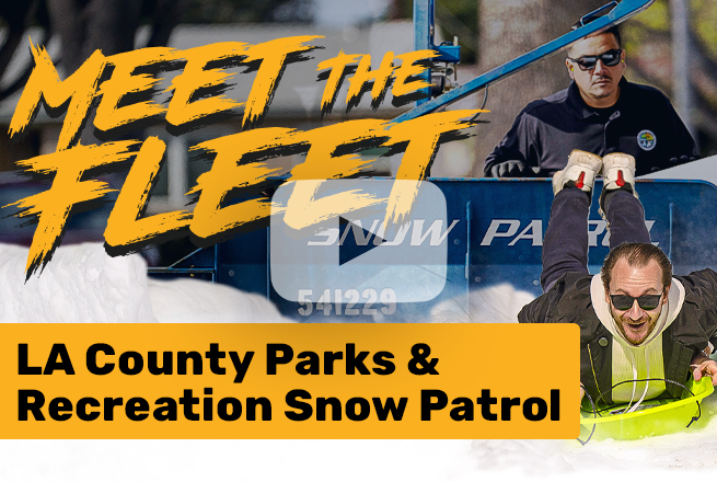 Man on snow sled going down snow, and man with sunglasses standing behind snow patrol machine