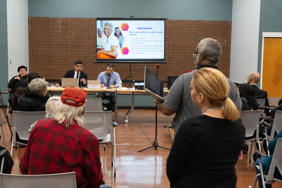 man offers comments at public hearing while others wait to speak
