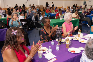 A group of at Altadena Satelite Senior Center fill aroom with festive tables.