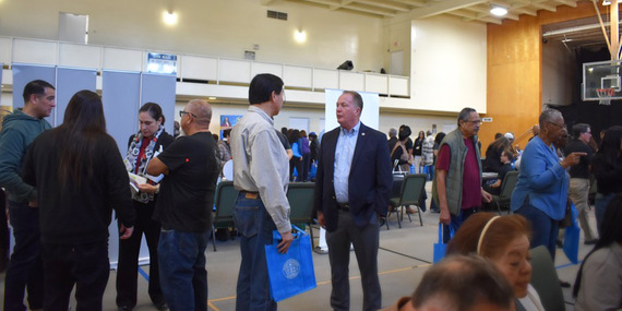 Assessor Prang speaks with attendee at the gym Inglewood Homeowners' Resource Fair