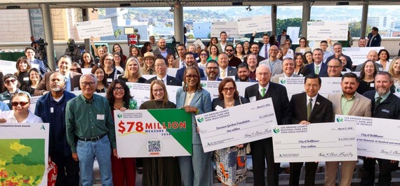 Representatives from awarded organizations and agencies holding their Measure A checks in celebration. 