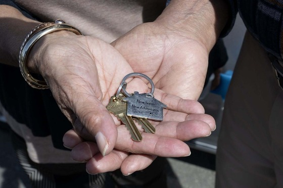 a pair of hands holding a set of keys 