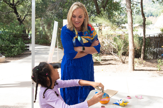 Supervisor Kathryn Barger observes a young girl doing a craft 