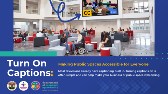 A large lobby full of people, including a person in a wheelchair, shows a public TV screen that displays closed captioning. 