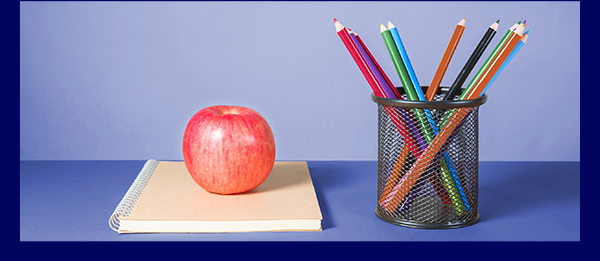 apple and colored pencils on a table