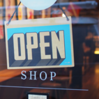 A sign saying "open" hangs on a store window 