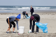 Individuals picking up trash on a beach
