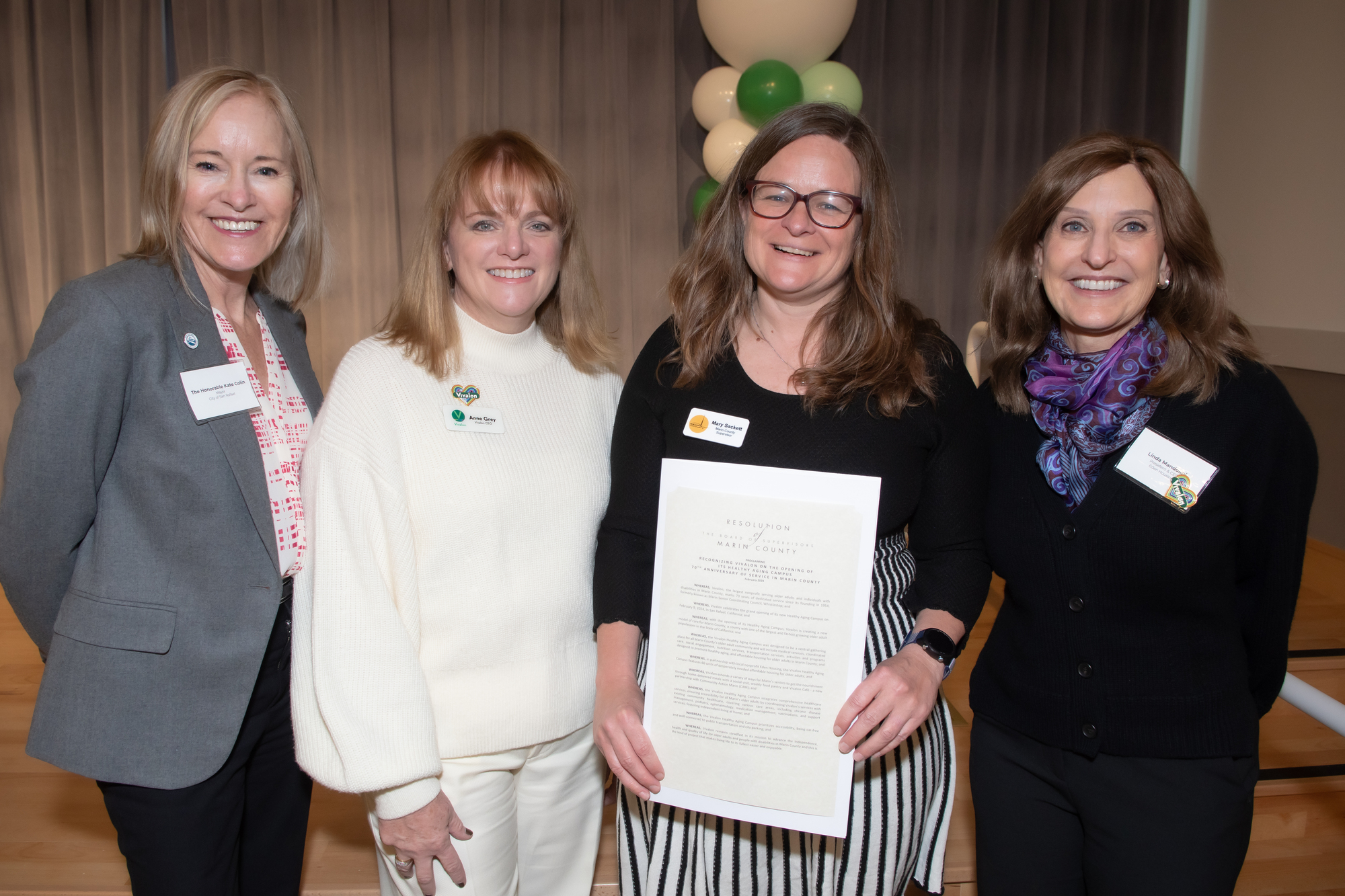 Vivalon CEO Anne Grey, Mayor Kate and Supervisor Sackett smiling to camera with Marin resolution in hand.