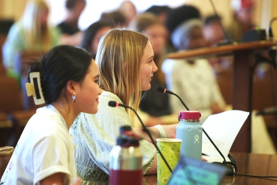 Two female students speak at microphones during a Youth Town Hall