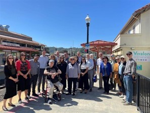 group smiling toward camera standing on SMART downtown San Rafael platform