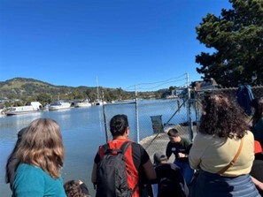perspective of backs of people looking at water measurement at Canal's edge