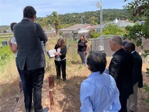 group standing alongside timber reinforced berm watching Mary point to map