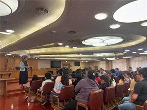 students sitting in audience listening to Supervisor Sackett in board chambers