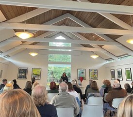 Supervisor Sackett speaking to seated audience in clubhouse